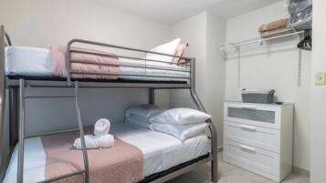 Een stapelbed met bureau en een plank.