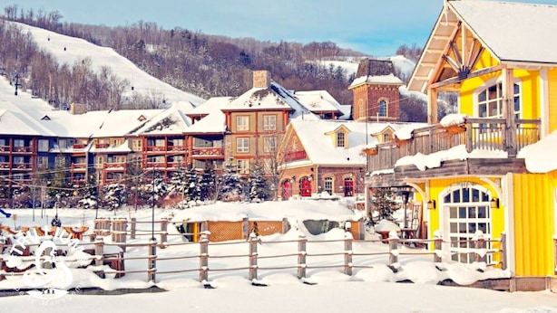 A snow-covered village with traditional wooden buildings, a ski lift, and a mountain backdrop. - Slopeside Loft at North Creek Resort  (The Blue Mountains)