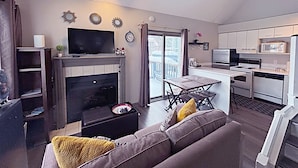 A modern living room with a fireplace, a television, and a sofa with cushions. - Slopeside Loft at North Creek Resort  (The Blue Mountains)
