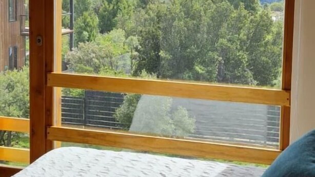 Un dormitorio con un ventanal que ofrece vistas a la montaña.