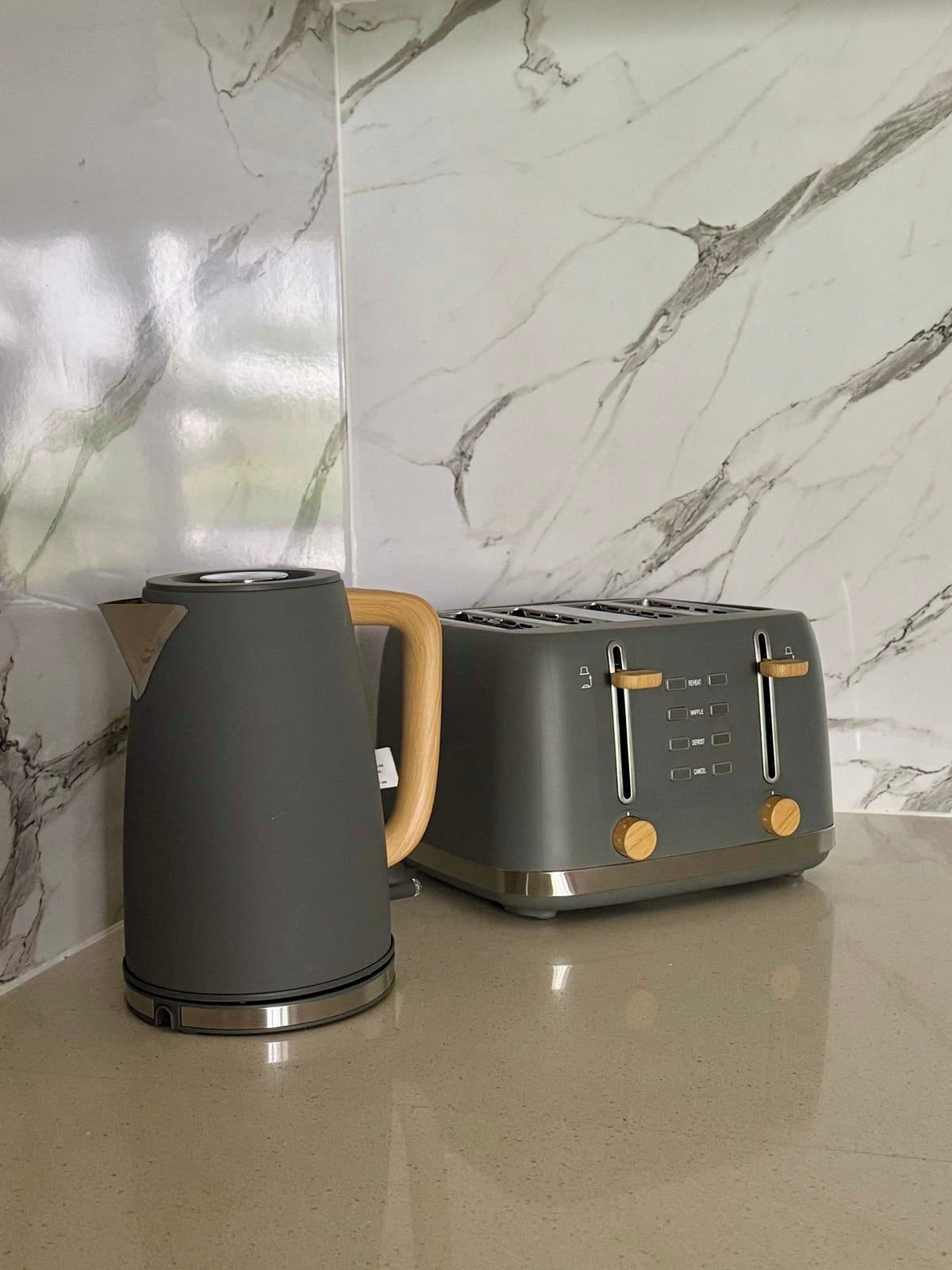 A kitchen counter with a kettle and a toaster.