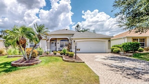 A residential house with a well-maintained lawn, a driveway, and a garage. - 1 Mi to Lake Sumter! Family Retreat w/ Large Patio (The Villages)