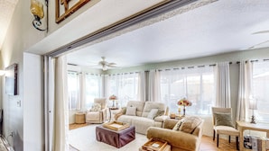 A spacious living room with a large sofa, a coffee table, and a side table with a lamp. - 1 Mi to Lake Sumter! Family Retreat w/ Large Patio (The Villages)