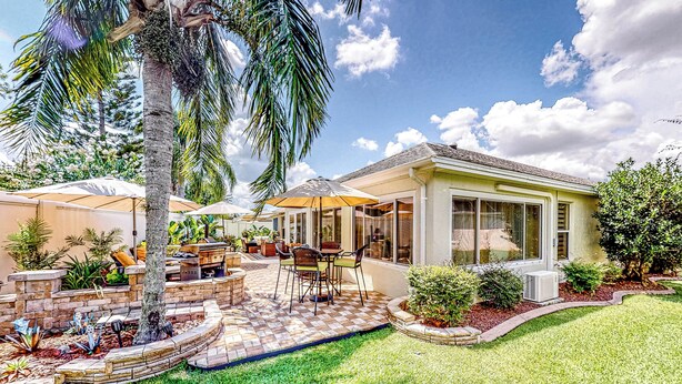 A backyard with a patio, outdoor furniture, and a palm tree. - 1 Mi to Lake Sumter! Family Retreat w/ Large Patio (The Villages)