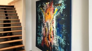 A modern interior with a staircase and a large abstract painting on the wall. - Hotel Gallery Boutique (Pereira)