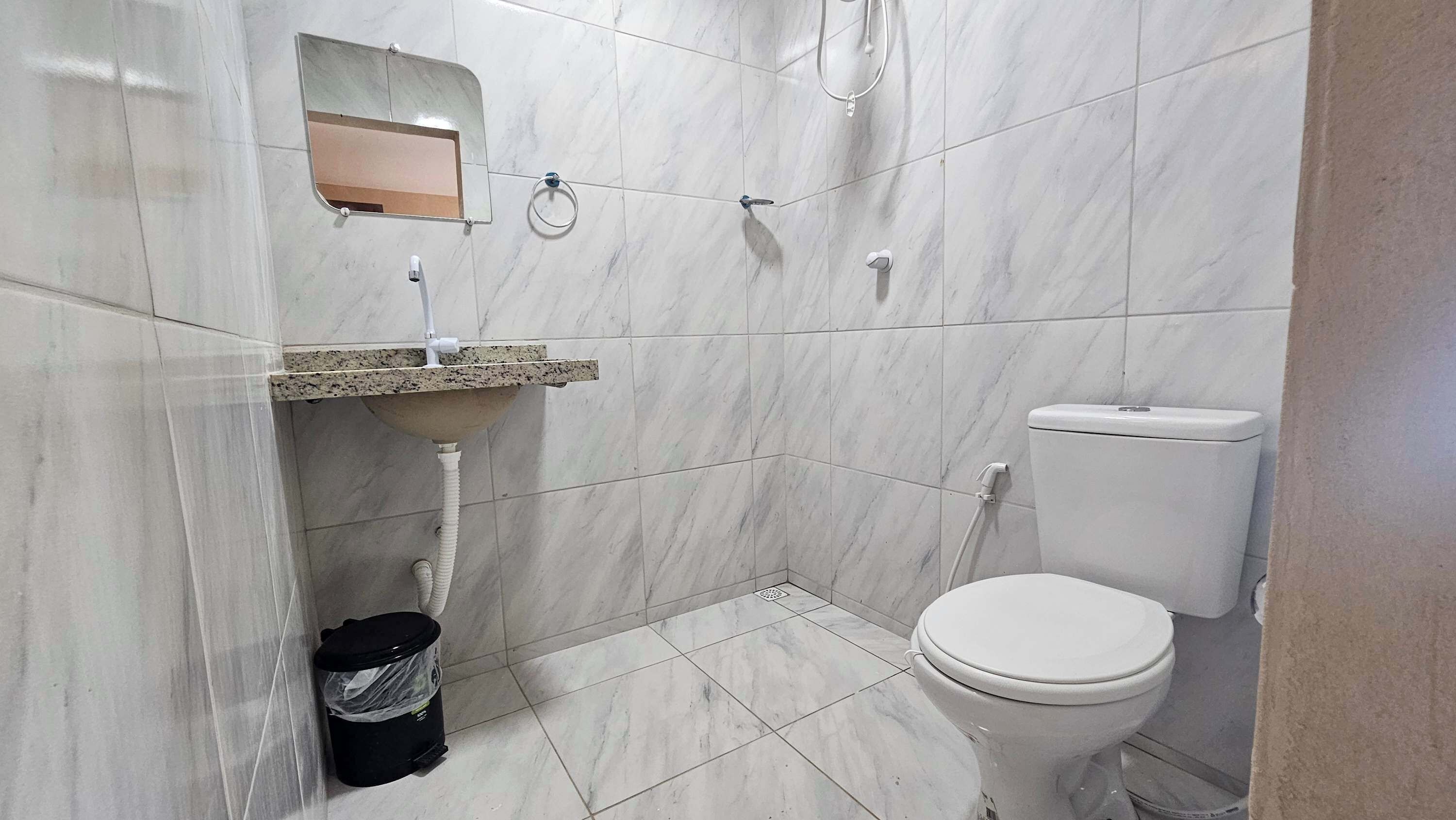 Ein Badezimmer mit Toilette, Waschbecken und Spiegel.
