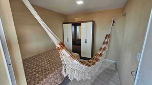 A bedroom with a bed, a wardrobe, and a hammock. - Penthouse by the Beach Near Rancho do Peixe & Jeri (Preá - CE)