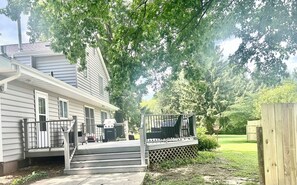 A house with a covered porch, steps leading to the entrance, and a fenced yard.