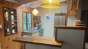 A modern kitchen with wooden accents, a built-in sink, and a stainless steel refrigerator.