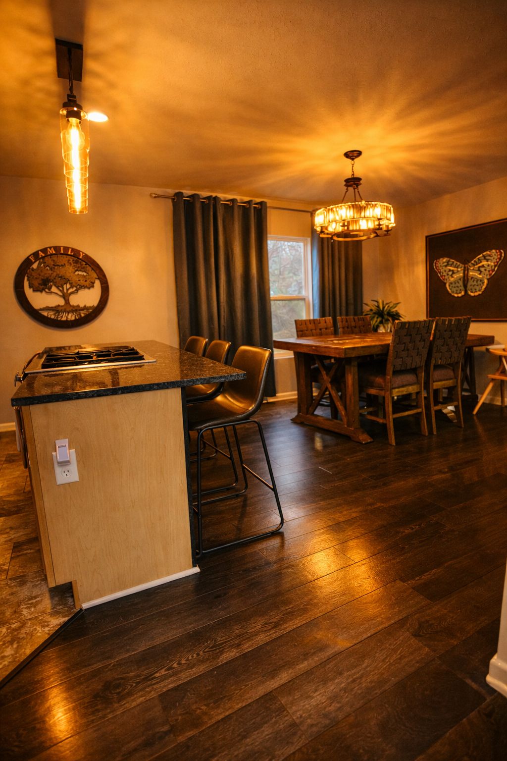 A cozy kitchen with a dining area, wooden flooring, and a family-themed wall decoration.
