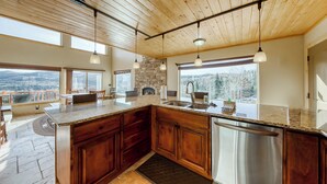 Une cuisine spacieuse avec des meubles en bois, un grand îlot central et un lave-vaisselle en acier inoxydable.