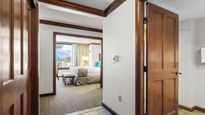 A hotel room with a bed, a chair, and a view of the mountains. - Valley-View Unit in Everline Resort: Premier Perks (Olympic Valley)