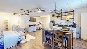 A modern apartment with a dining area, kitchen, and living room.
