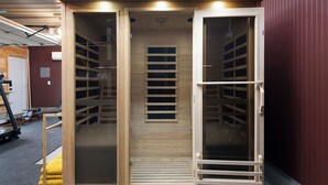 Ein begehbarer Kleiderschrank mit Schiebetüren, Holzinnenraum und Metallrahmen.