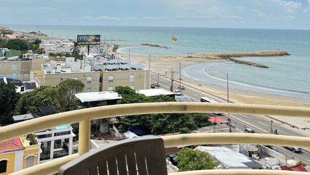 A balcony with a view of a beach, a road, and buildings in the distance. - Sea view and historical center (with swimming pool and in front of the beach in Marbella) (Cartagena de Indias)