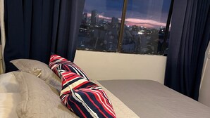A bed with a quilted cover, two pillows, and a striped pillow. - Sea view and historical center (with swimming pool and in front of the beach in Marbella) (Cartagena de Indias)