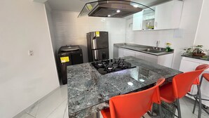 A modern kitchen with a central island, a built-in stove, a refrigerator, and a sink. - Sea view and historical center (with swimming pool and in front of the beach in Marbella) (Cartagena de Indias)