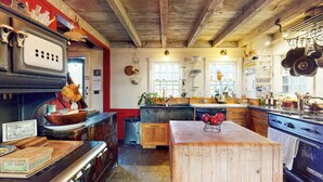 Una cocina rústica con un horno grande, armarios de madera y una isla central.