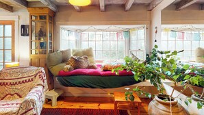 Una habitación acogedora con una cama, una silla, una mesita y una planta en maceta.