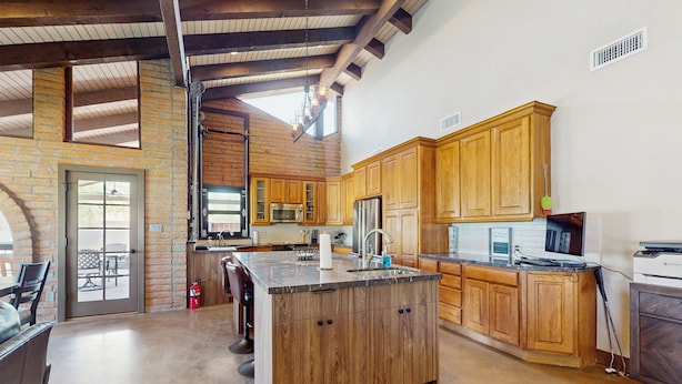 Una cocina amplia con armarios de madera, una isla grande y vistas al exterior.