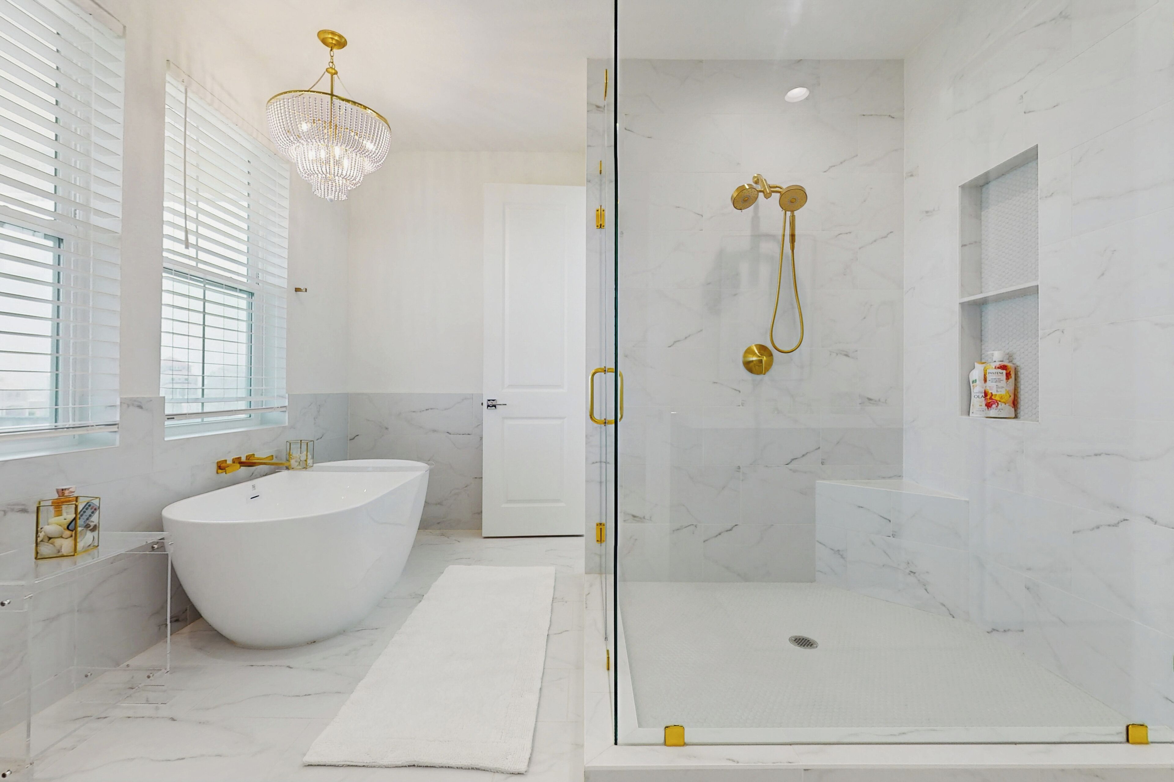 A modern bathroom with a freestanding bathtub, a glass-enclosed shower, and marble walls.