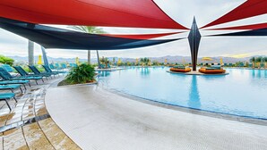 A pool area with lounge chairs and a central water feature. - Mtn-View Patio & Resort Perks: Verde River Retreat (Rio Verde)