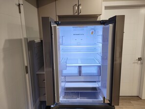 Een open koelkast met een label 'All-Around Cooling', een transparante deur en een roestvrijstalen afwerking.