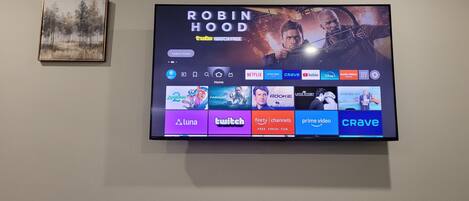Ein Flachbildfernseher an der Wand, neben ihm ein 'Robin Hood' Filmplakat und ein gerahmtes Bild.