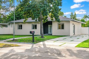 Une maison moderne à deux étages, dotée d’une pelouse bien entretenue, d’une boîte aux lettres et surplombant un ciel dégagé.