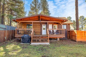 A wooden cabin with a deck, a covered grill, and a fenced yard. - Cozy Cabin in the Pines w/ Grill & Outdoor Dining (Flagstaff)