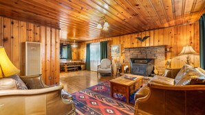 L’intérieur d’un chalet confortable, avec une cheminée, des meubles en cuir et un tapis à motifs.
