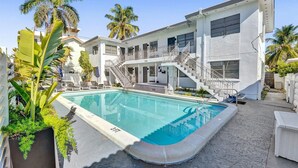 Ein modernes Gebäude mit Pool, Treppe und Balkon.