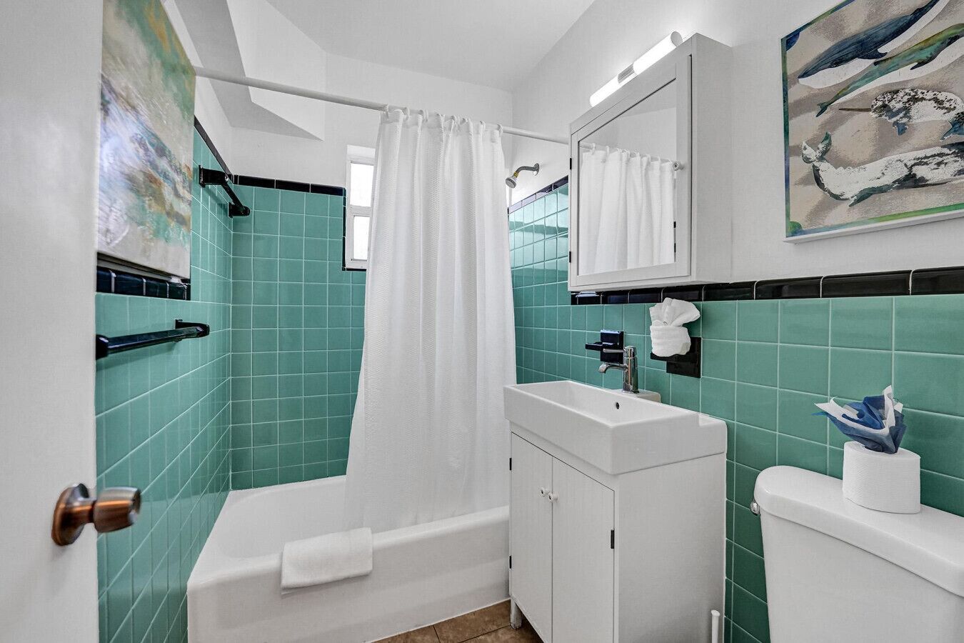 A bathroom with a bathtub, a sink, a toilet, and a shower curtain.