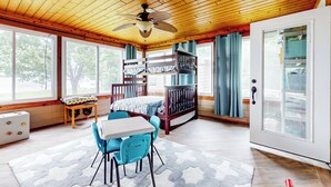 A cozy room with a wooden ceiling, a bunk bed, a desk with chairs, and a large window. - Waterfront Home on Lake Limestone w/ Dock (Groesbeck)