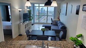 Une cuisine moderne dotée de plans de travail en granit, d’un évier double et d’un coin repas avec une table et des chaises.