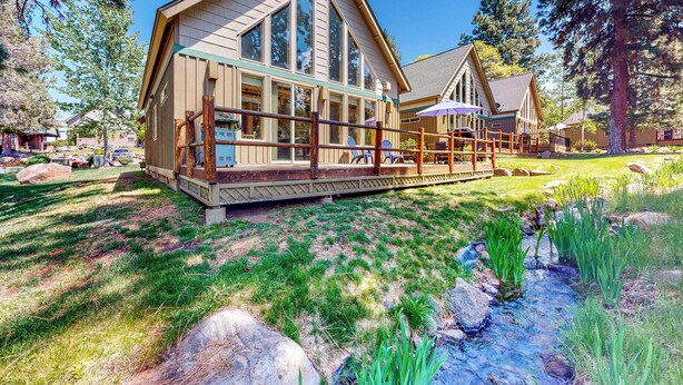 A lodge with a large deck, a pond, and a forested backdrop. - Gateway to Crater Lake! Resort Retreat w/ Pool (Klamath Falls)