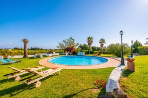 A swimming pool with lounge chairs, a lamp post, and surrounding greenery. - Enjoy relaxed Algarve living in Fuseta with a shared pool and garden views. (Fuseta)