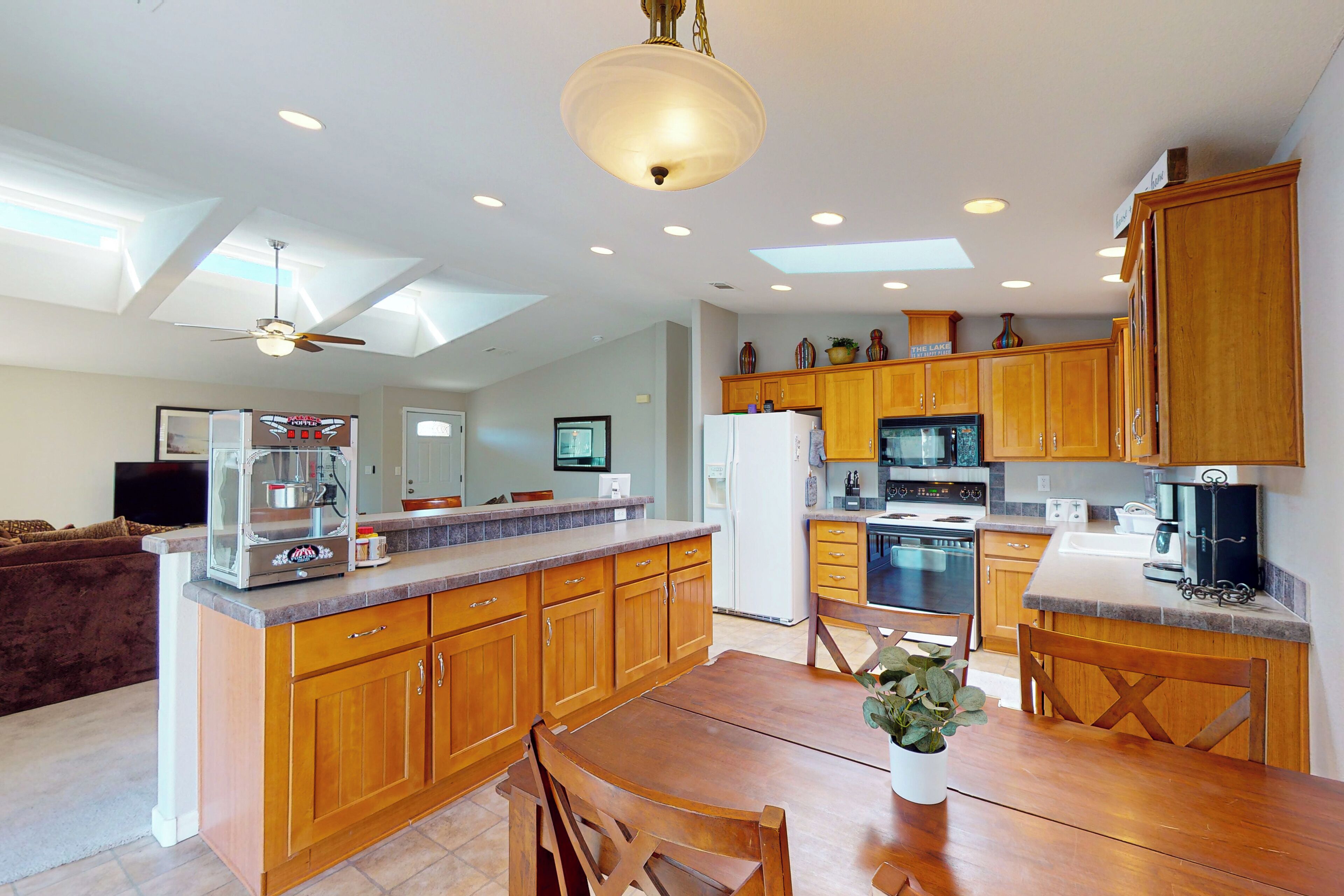 A spacious kitchen with wooden cabinets, a large island, and modern appliances.