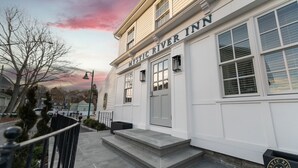 A two-story building with a sign reading "Mystic River Inn."
