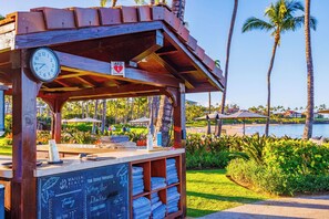 A beachside kiosk with a clock, a sign indicating AED availability, and a chalkboard with service provider information. - Wailea Beach | Oceanfront 6 BR, Sleeps 12 | Car Incl. w/ 6+ Nights | WBV ML-3485 by KBM (Wailea)