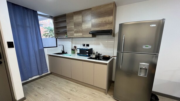 Una cocina moderna con un refrigerador de acero inoxidable, un microondas y un lavaplatos.