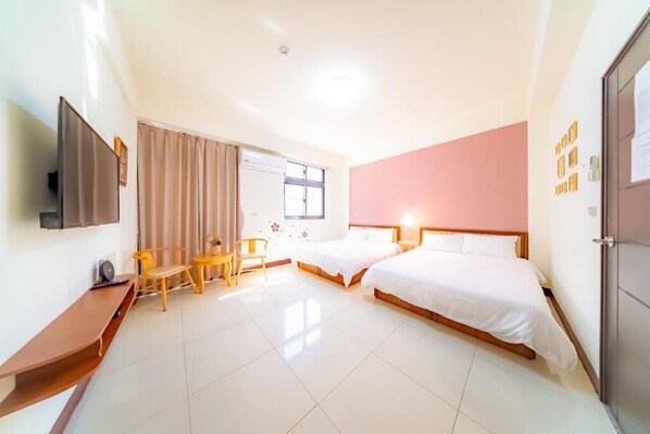 A hotel room with two beds, a TV, a desk, and a window with curtains. - Xiyue Homestay (Jinhu)