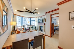 A cozy living room with a fireplace, a dining area, and a television. - Olympic Valley Summer Stay! 2BR in Everline Resort (Olympic Valley)