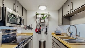 A compact kitchen with stainless steel appliances, a sink, and a trash bin. - Mtn-View Balcony: Condo 6 Mi to Dtwn Phoenix (Phoenix)