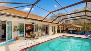 A covered swimming pool with a patio area, glass doors, and outdoor furniture. - Golfer's Oasis w/ Pool in Black Diamond Ranch! (Lecanto)