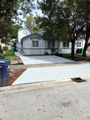 Una casa residencial con un jardín delantero, entrada para coches y buzón.