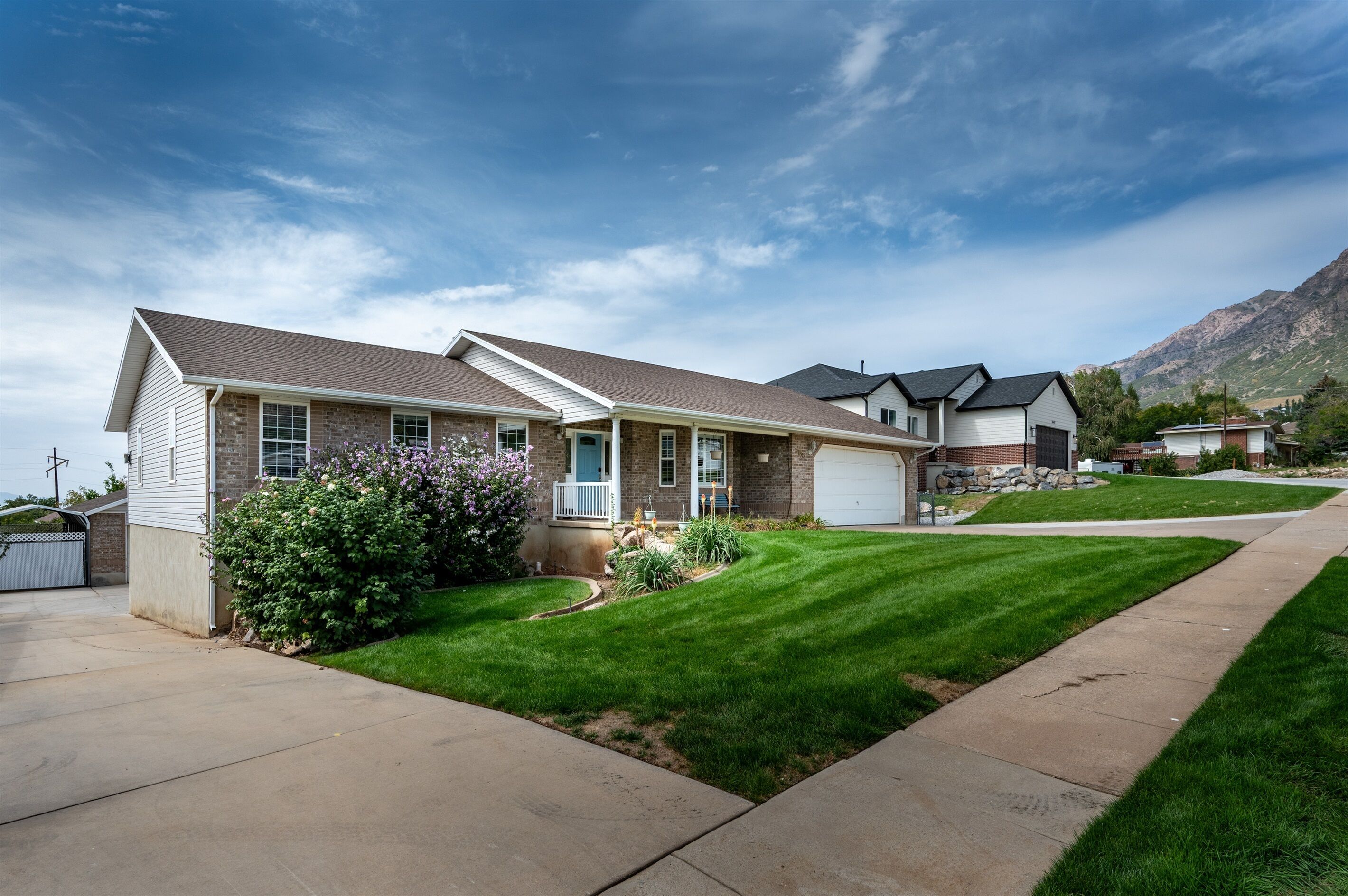 A single-story house with a front porch, a garage, and a well-maintained lawn.