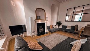 A modern living room with a fireplace, a large mirror, and a sectional sofa.