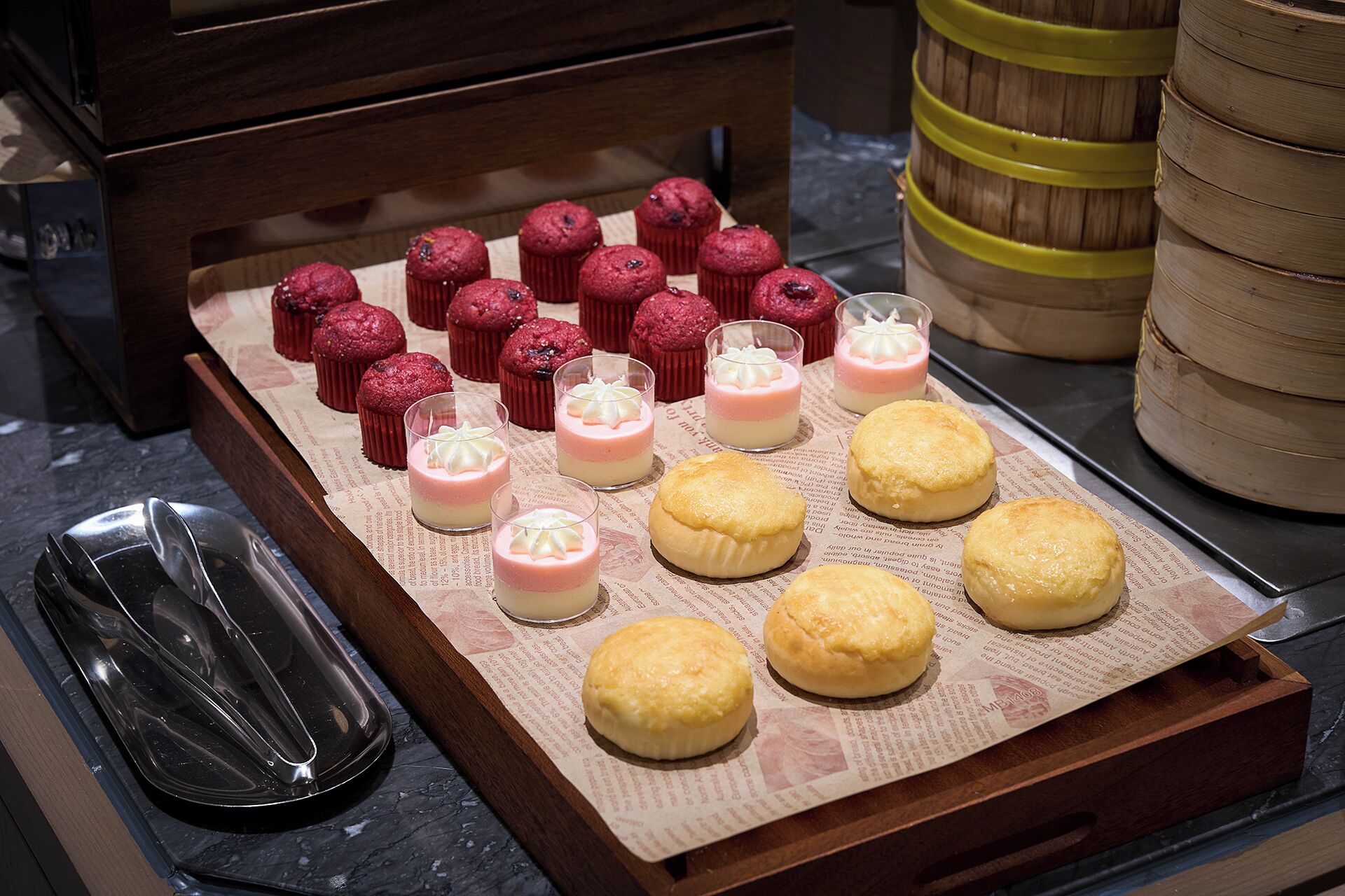 A tray of pastries and desserts on a wooden surface.