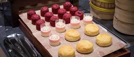 A tray of pastries and desserts on a wooden surface.